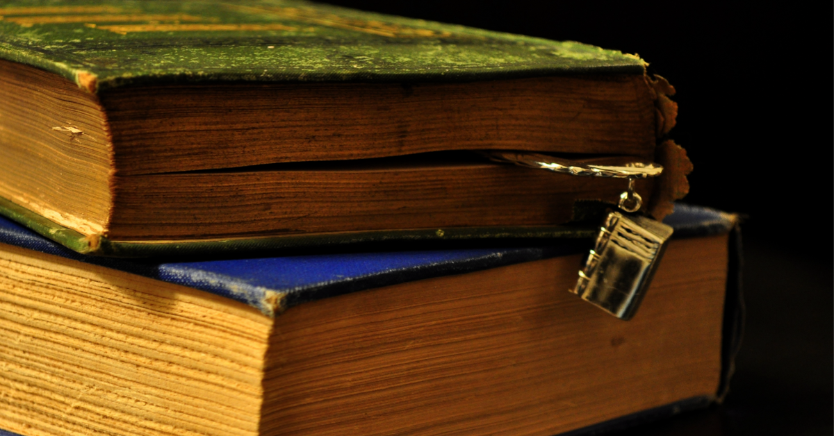 Two old books seen from the side: One with a green cover and a metal bookmark stacked slightly ajar on one with a blue cover. Image credit: Old Books (https://flic.kr/p/9ot8E8) by Zan Ready, licensed CC BY-SA (https://creativecommons.org/licenses/by-sa/2.0/).