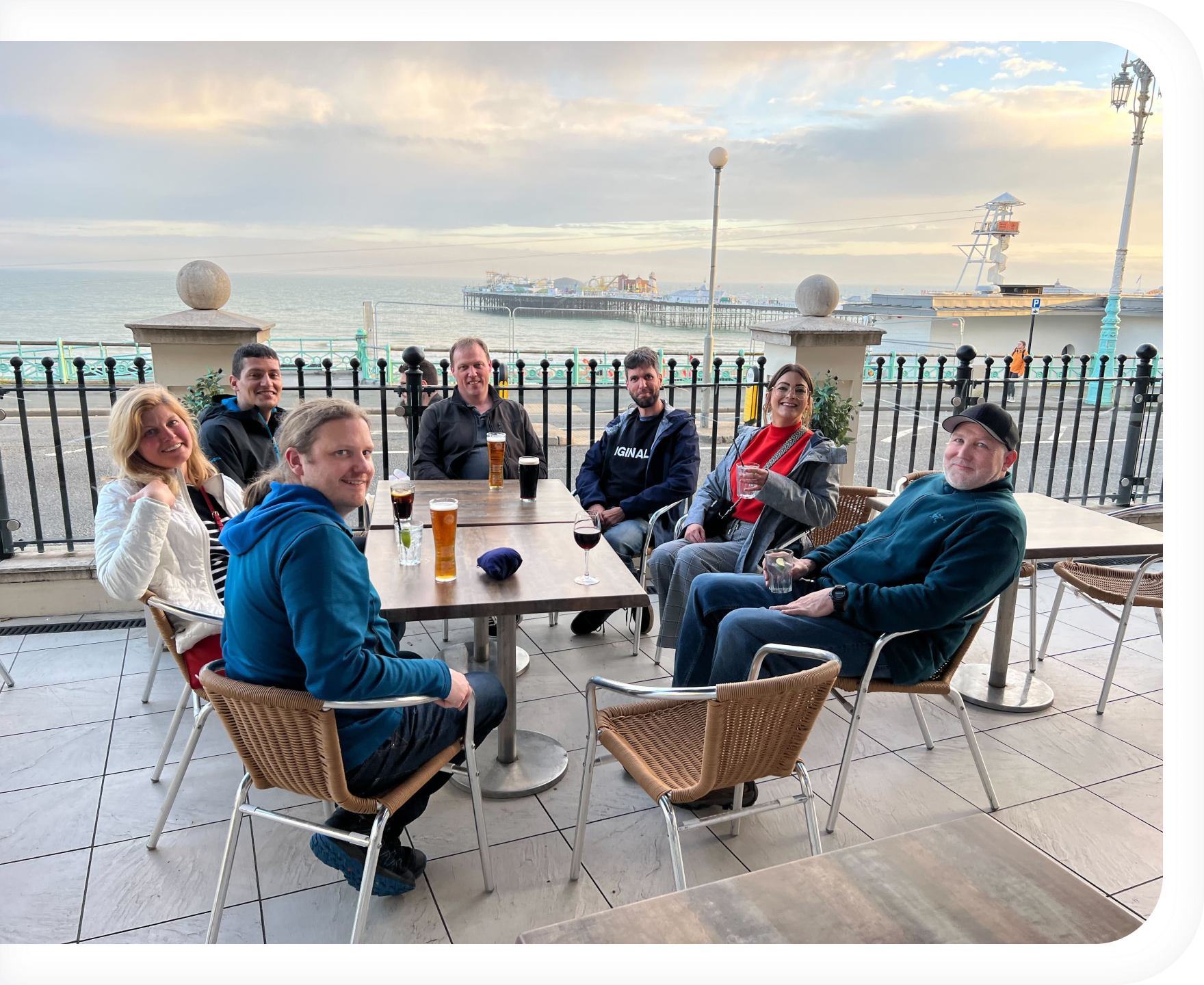 several staff members sitting outside, around a table